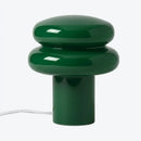 Green table lamp with a cylindrical base and rounded top on a white background