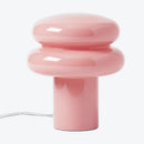 Pink table lamp with a cylindrical base and rounded top on a white background