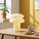 Decorative lamp on a table with a cup of coffee and cookies in a bright room.