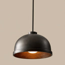 Black pendant light with a warm glow on a beige background