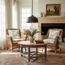 Cozy living room with wicker chairs, a round wooden table, and a fireplace.