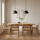 Dining room with wooden table and chairs, black pendant lights, and decorative wall art.