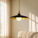Pendant light with black shade and gold trim hanging in a room with beige curtains and sofa.