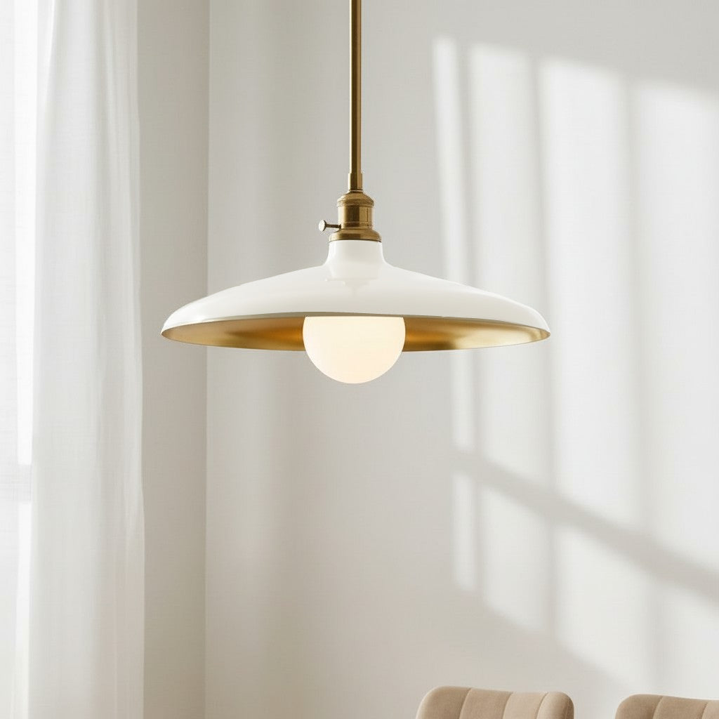 Modern pendant light with white shade and gold trim against a neutral wall.