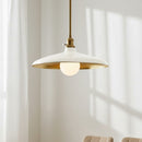 Modern pendant light with white shade and gold trim against a neutral wall.