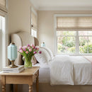 Neatly arranged bedroom with a bed, side table, and decorative elements.