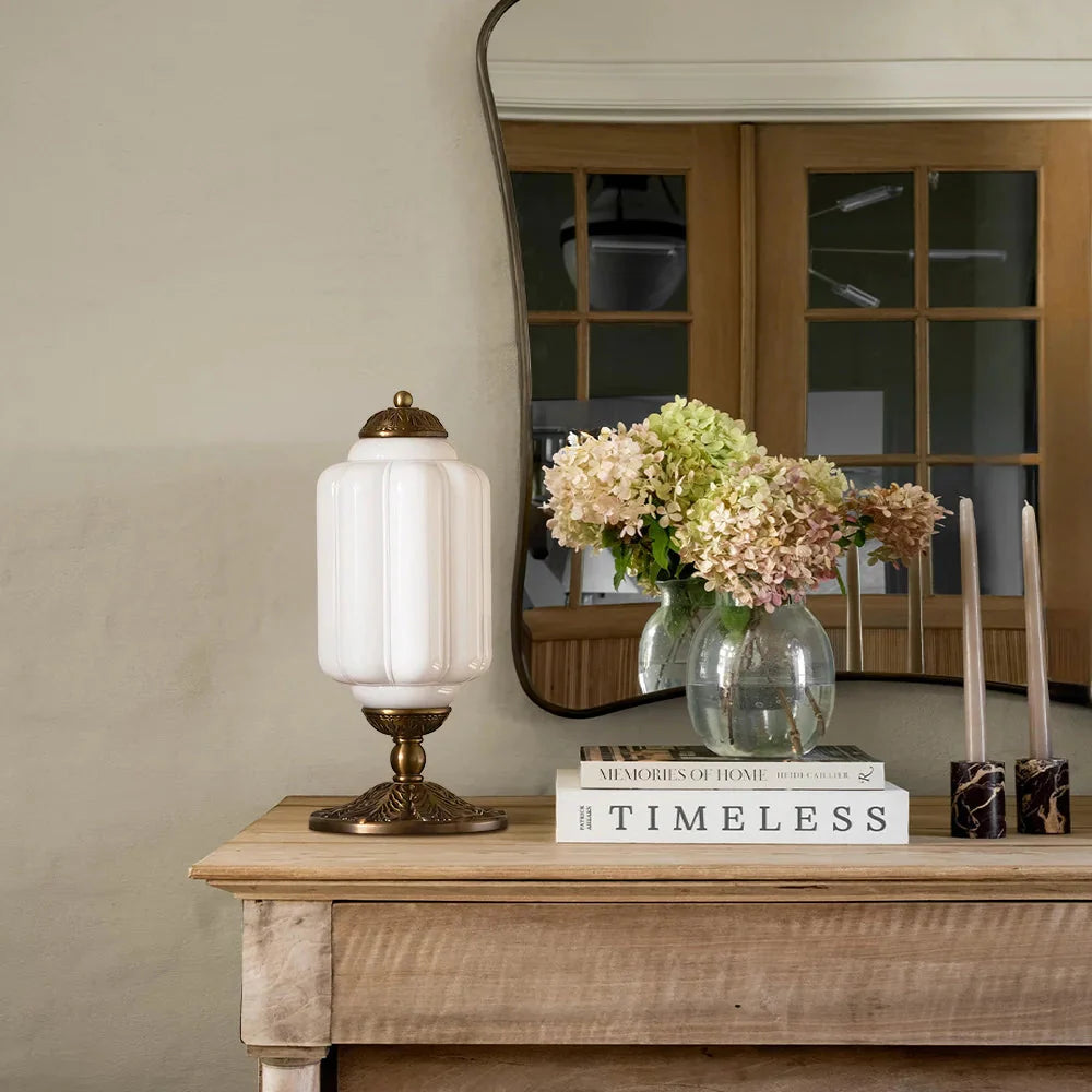 Decorative table with lamp, books, and flowers in a home setting