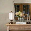 Decorative table with lamp, books, and flowers in a home setting