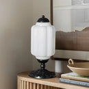 Decorative table lamp on a wooden surface with a blurred background