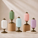 Set of five decorative lamps with different colored glass shades on a neutral background