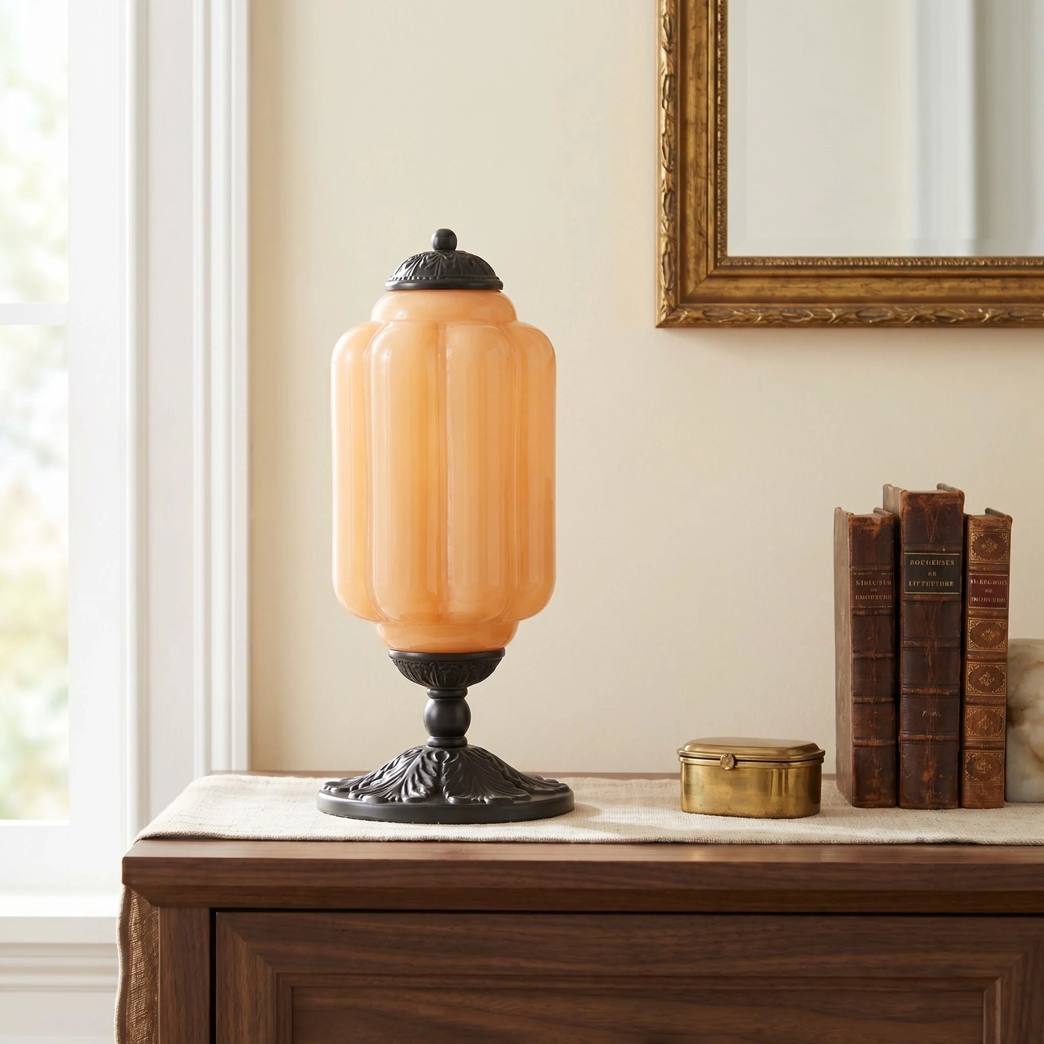 Vintage-style table lamp with an orange glass shade on a wooden surface.