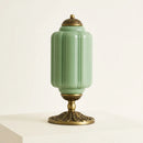 Decorative green vase with gold base and lid on a white background