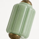 Green ceramic jar with gold decorative elements on a white background