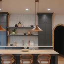 Modern kitchen with dark cabinets, a light wood island, and wooden chairs.