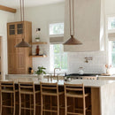 Modern kitchen with wooden cabinets, island, and pendant lights.