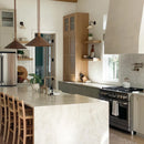 Modern kitchen with marble island, stainless steel appliances, and wooden chairs.