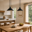 Modern kitchen with wooden dining table and chairs, black pendant lights, and large windows.
