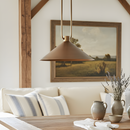 Modern pendant light hanging above a sofa with decorative elements in a living room.