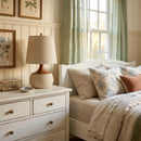 Neatly made bed with decorative pillows in a bedroom setting.