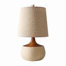 Table lamp with a beige fabric shade and wooden base on a white background