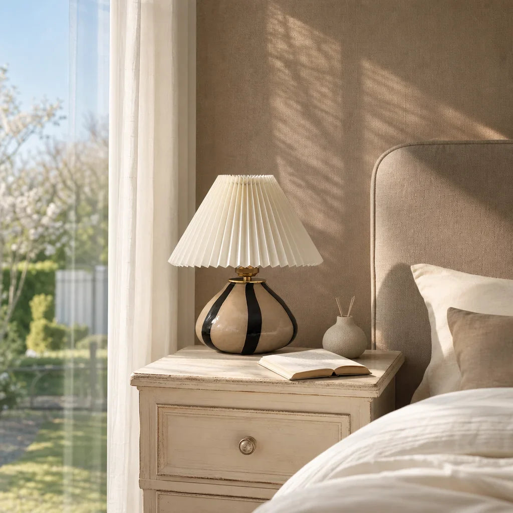 Napoleon Chateau lamp on a nightstand next to a bed with pillows