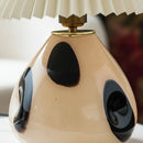 Decorative lamp with a beige base and black accents on a blurred background