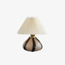 Decorative table lamp with pleated shade on a white background