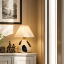 Decorative lamp on a cabinet with a framed picture in the background