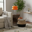 Living room with a beige sofa, orange lamp, and decorative items.