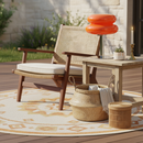 Outdoor seating area with wicker chair, table, and decorative items on a patio.