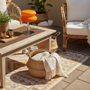 Outdoor patio with wooden table, wicker chairs, and decorative elements.
