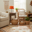 Living room with beige sofa, wicker chair, and decorative elements.