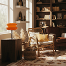 Cozy living room with a chair, lamp, and bookshelf.