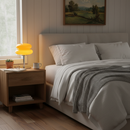 Cozy bedroom with a bed, nightstand, and lamp.
