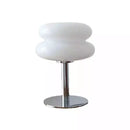 Modern table lamp with white glass shade and chrome base on a white background