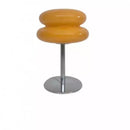 Yellow bar stool with a metallic base on a white background