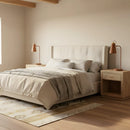 Modern bedroom with a bed, nightstands, and lamps in a warm color scheme.