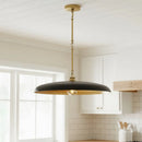 Black pendant light hanging in a kitchen with white cabinets and a window.