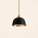 Pendant light with black shade and gold interior on a beige background