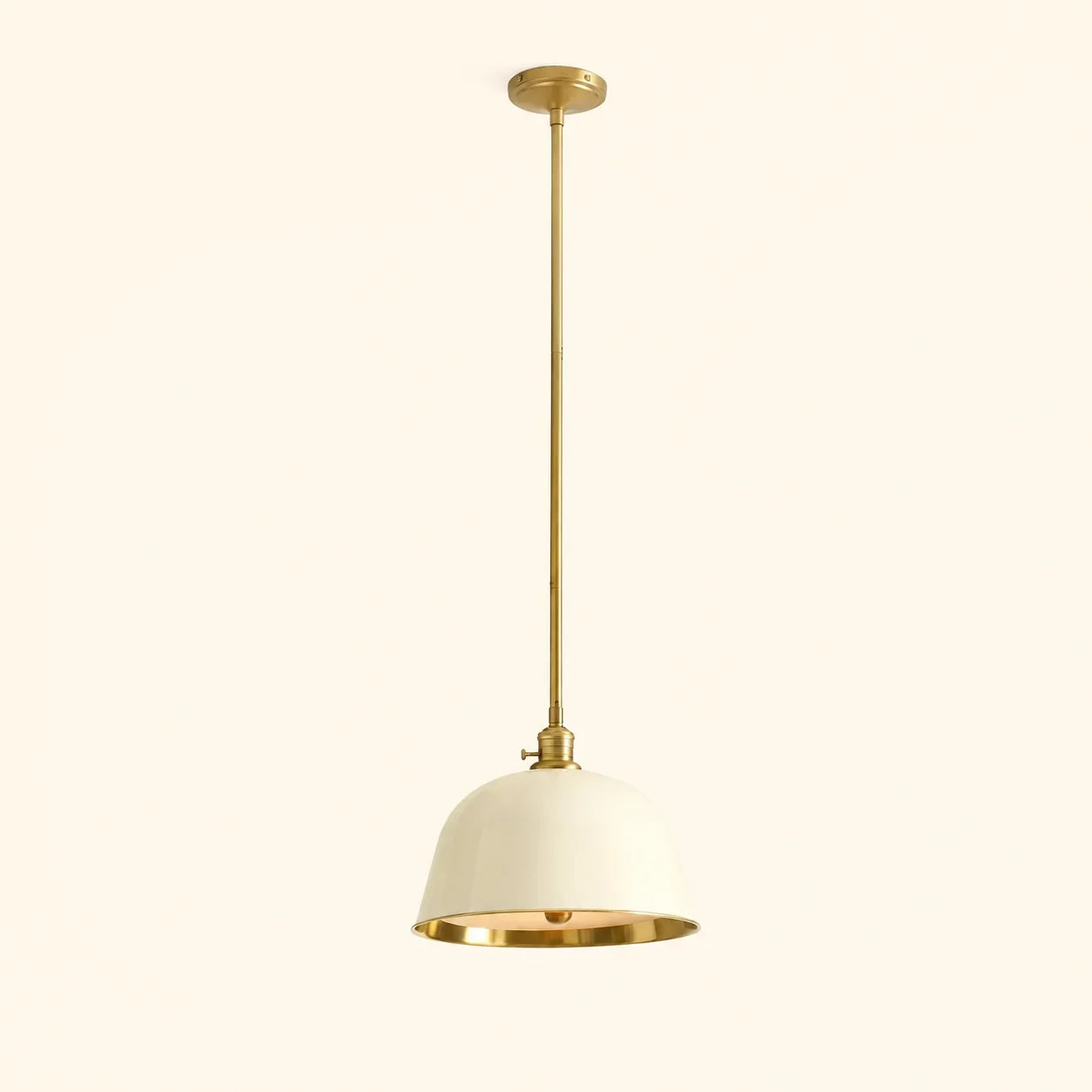 Pendant light with gold finish and white shade on a beige background