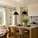 Modern kitchen with marble island, wicker chairs, and pendant lights.