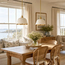 Dining room with wooden table, wicker chairs, and large windows with scenic view.