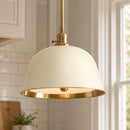 Pendant light with white shade and gold trim in a kitchen setting