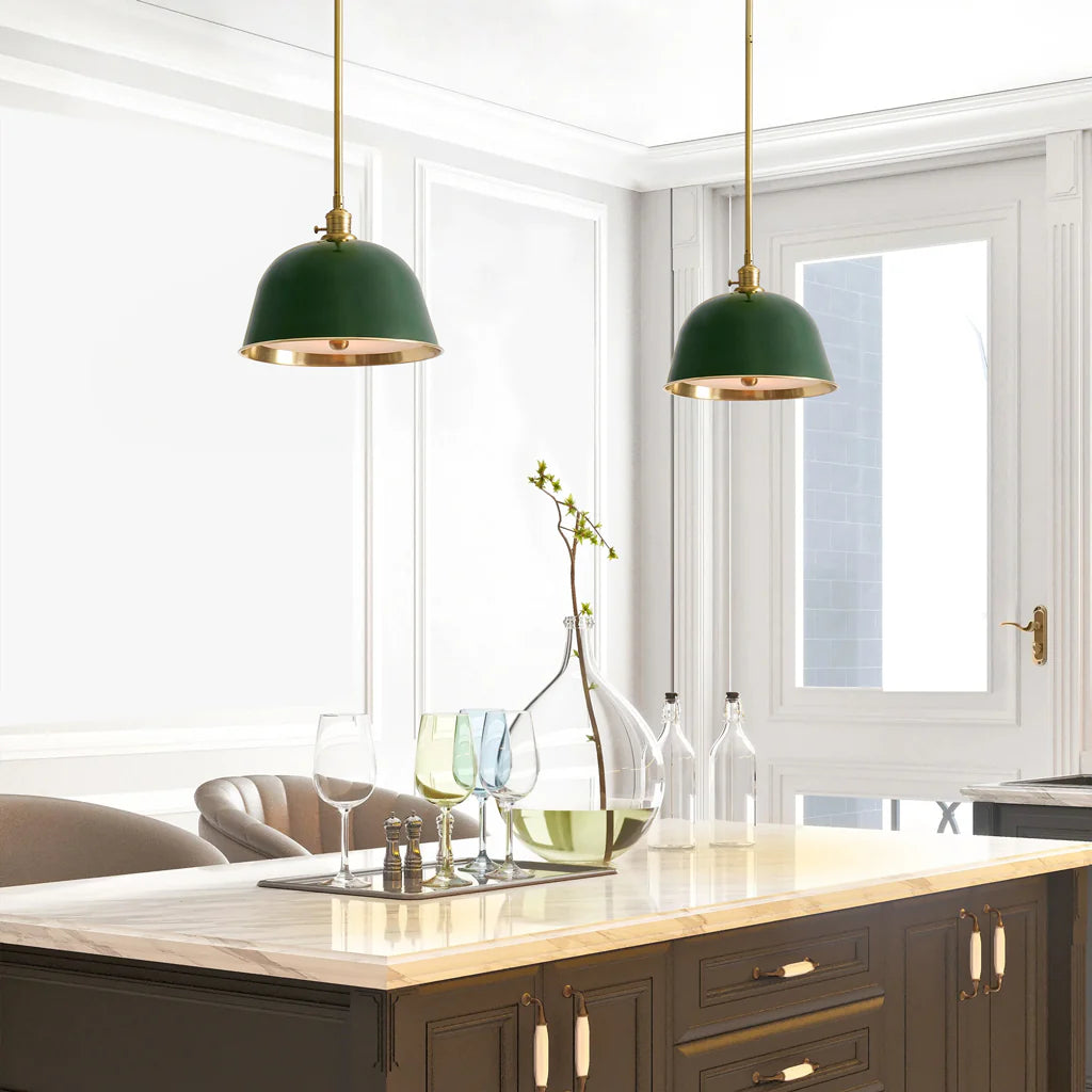 Modern kitchen with green pendant lights, marble island, and glassware.