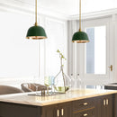 Modern kitchen with green pendant lights, marble island, and glassware.