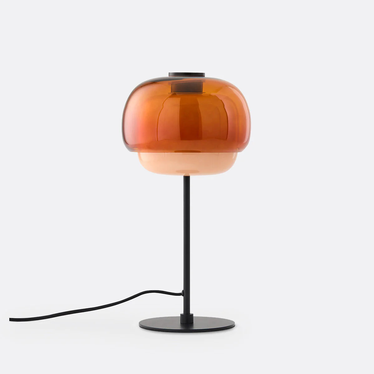 Table lamp with orange glass shade and black base on a white background