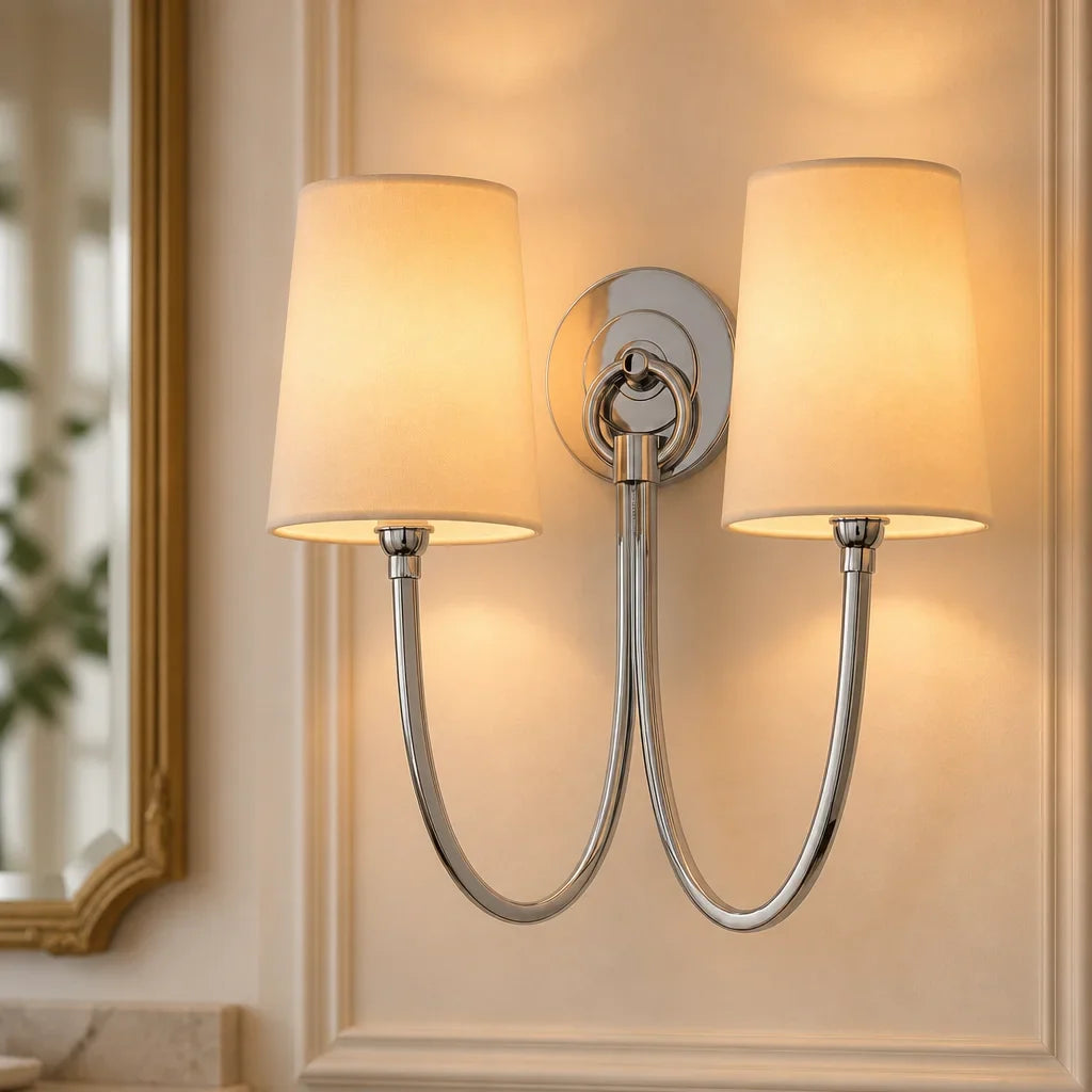 Double wall sconce with beige lampshades on a neutral wall.