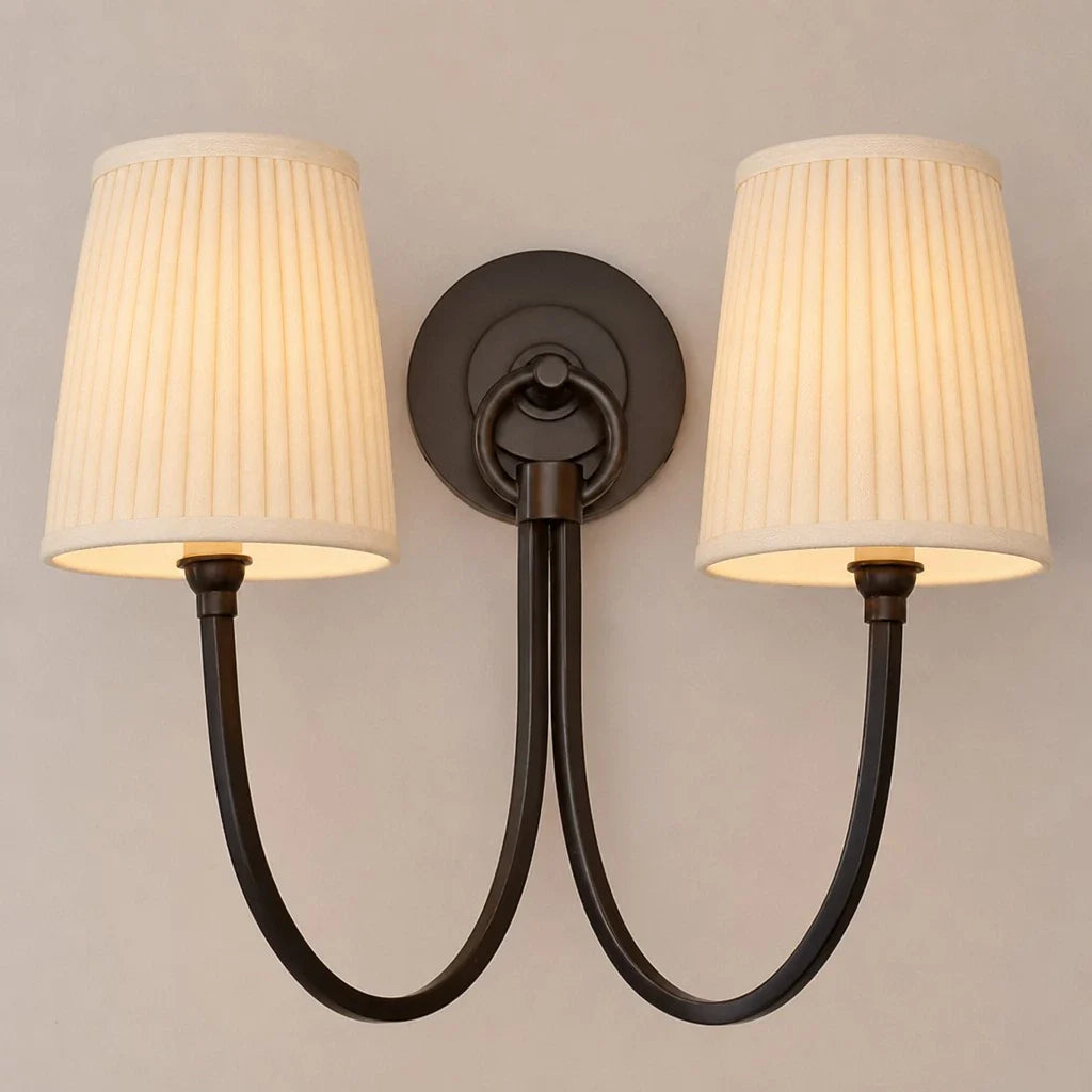 Double wall sconce with pleated lampshades on a neutral background