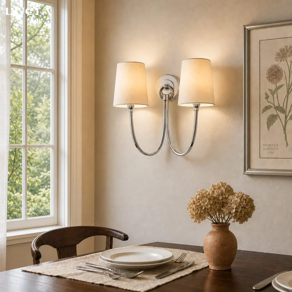 Dining room with a double wall sconce, window, and table setting.
