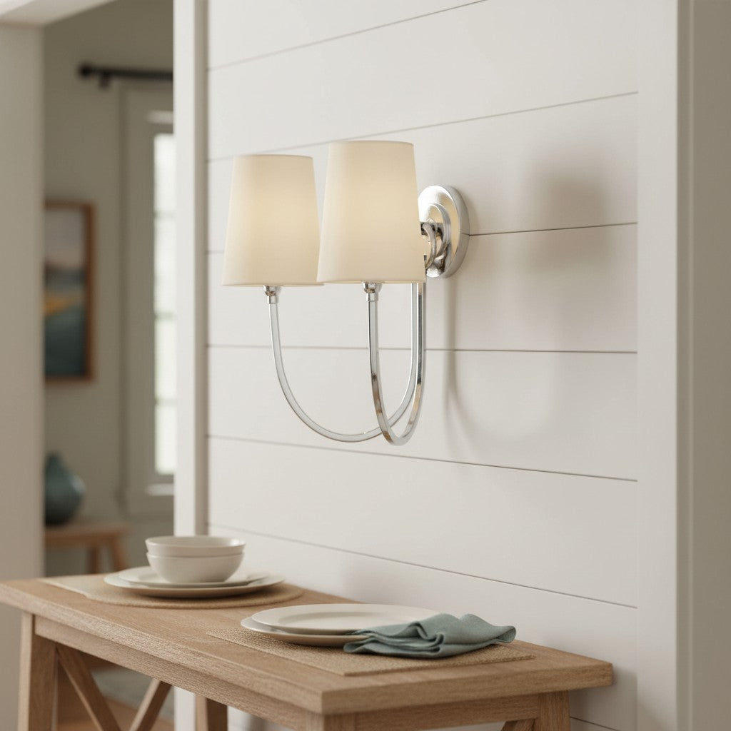 Wall-mounted lamp with a beige shade in a room with a wooden table and decor.